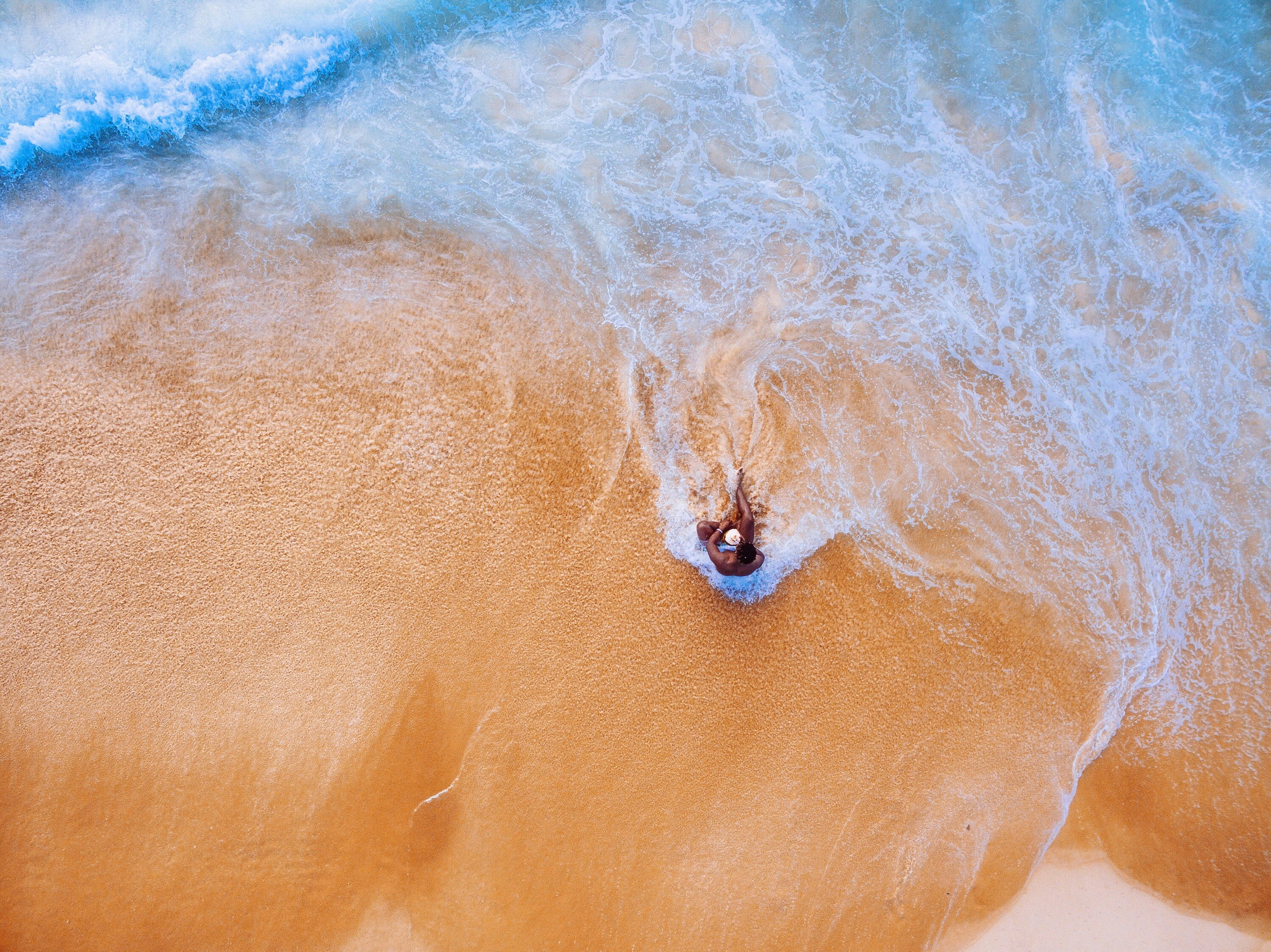 aerial photography of person sitting on sea